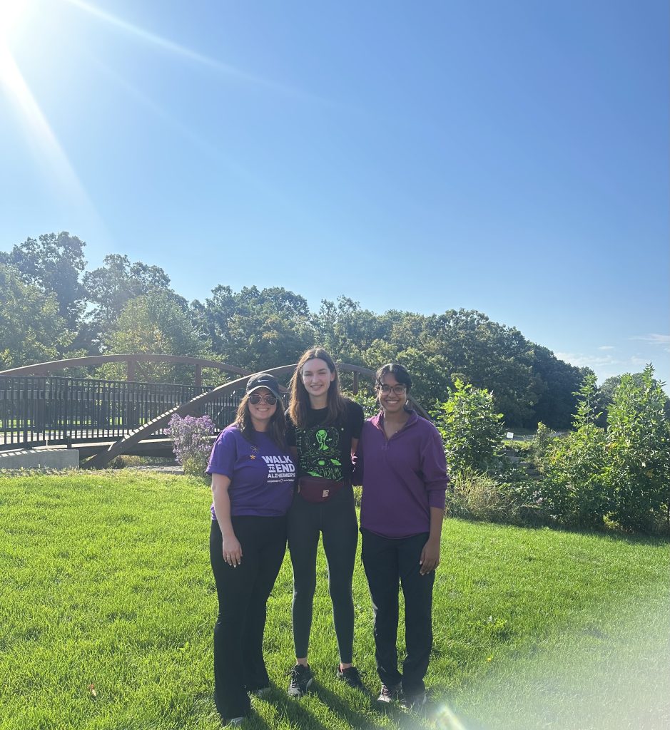 Right to Left: Ruvini Navaratna, Elena Ruiz De Chavez, and Finnuella Carey outside at Warner Park on a sunny day.