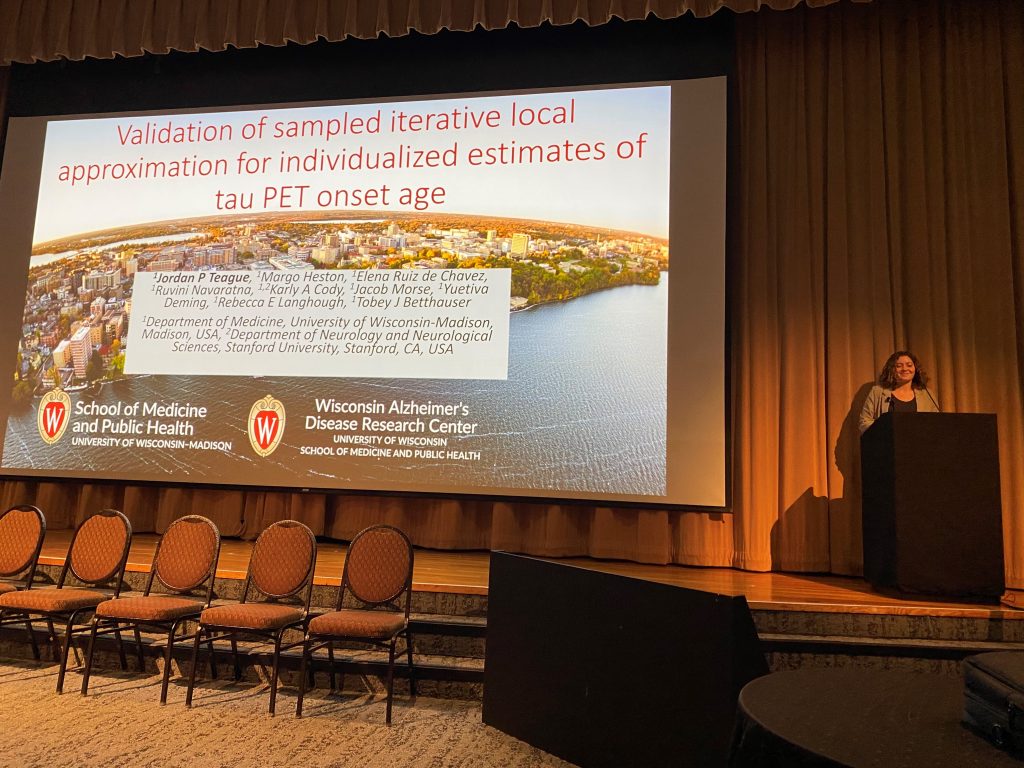 Graduate student Jordan Teague at the podium presenting at HAI 2024; title slide of talk shows in background.