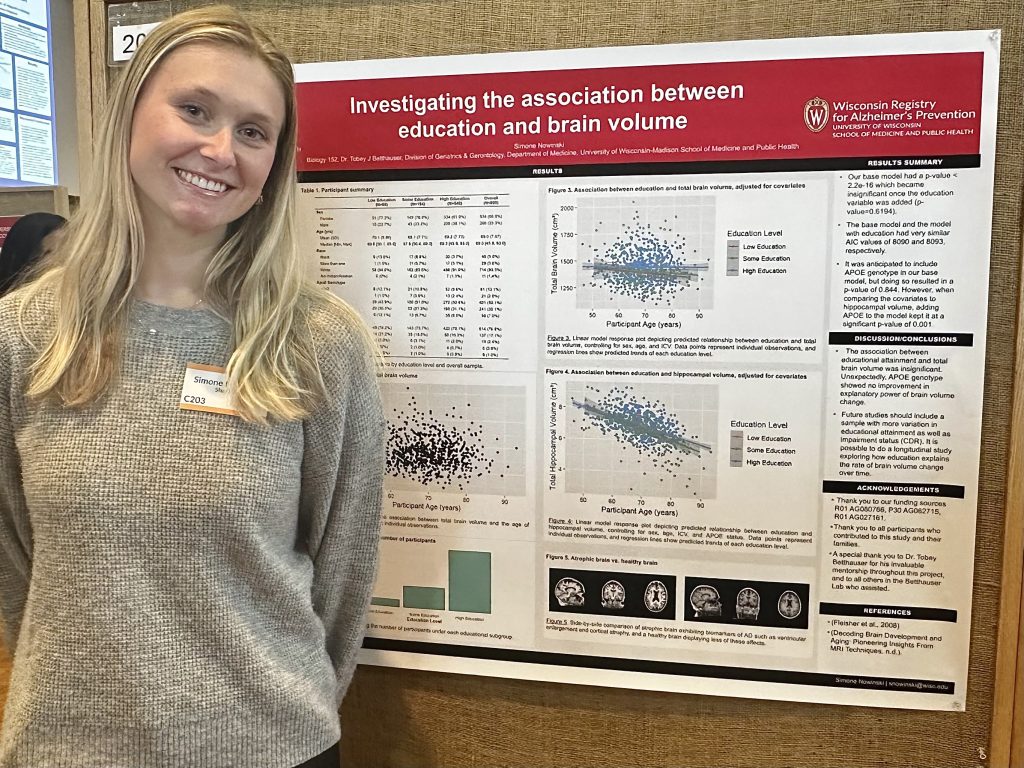 Simone Nowinski standing in front of poster at the 2025 Undergraduate Research Symposium.